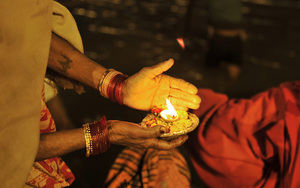 An Indian devotee holds an offering at the Sangam.
