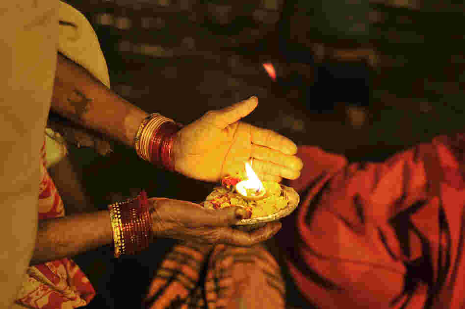 An Indian devotee holds an offering at the Sangam.