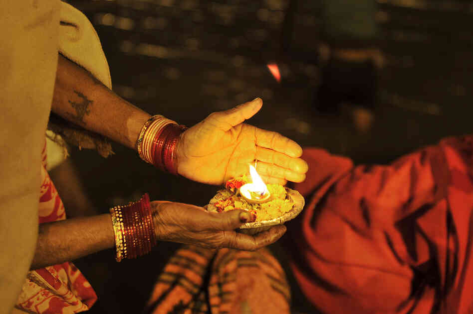 An Indian devotee holds an offering at the Sangam.