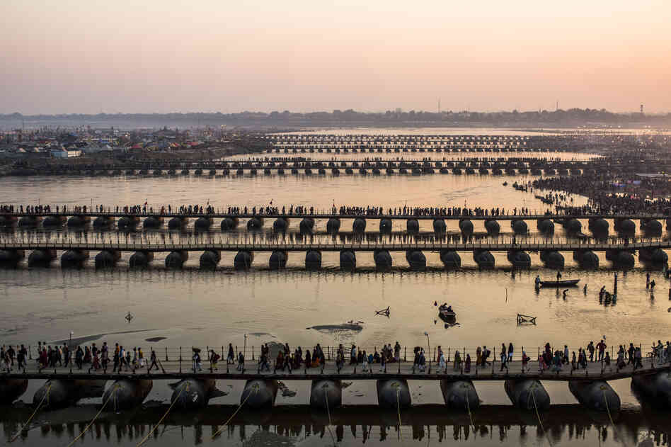 Pilgrims make their way over pontoon bridges.