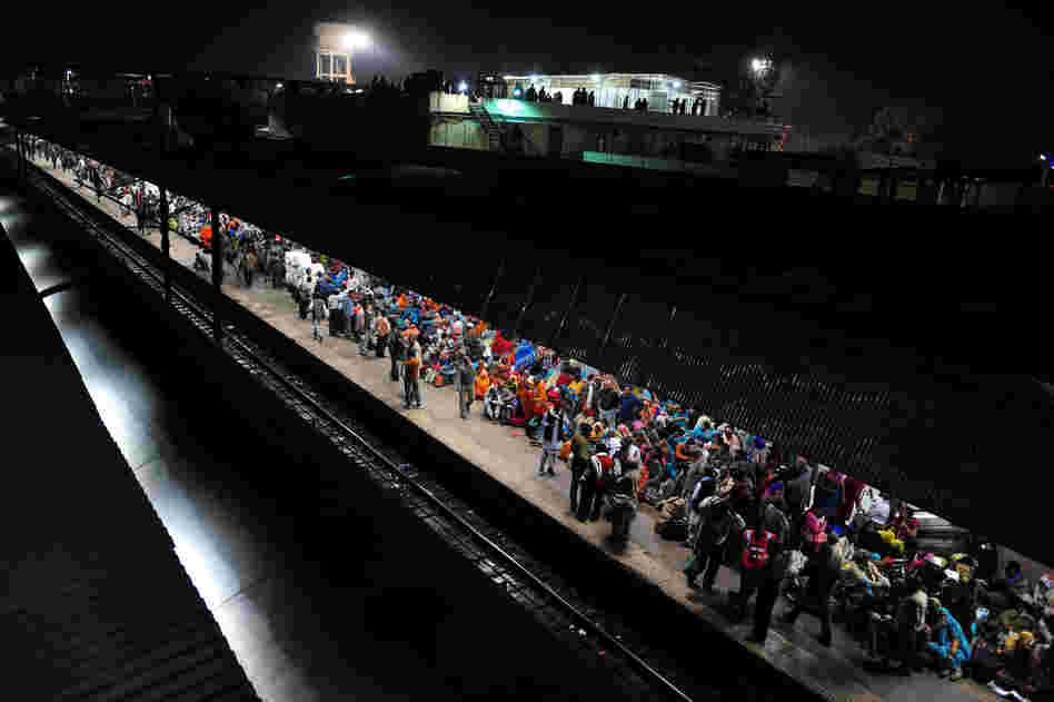 Hindu devotees wait Monday to board a train at the site of Sunday's stampede. Survivors blamed the tragedy on baton-charging police and the slow response of medics.