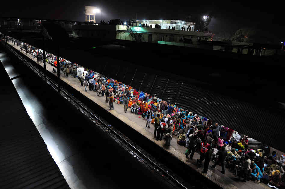 Hindu devotees wait Monday to board a train at the site of Sunday's stampede. Survivors blamed the tragedy on baton-charging police and the slow response of medics.