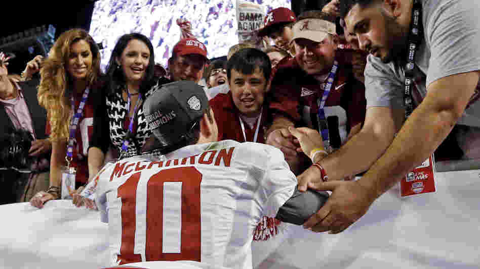 Katherine Webb (left), the girlfriend of Alabama quarterback A.J. McCarron, and McCarron's mother, Dee Dee Bonner (second from left), watch McCarron celebrate after the BCS National Championship college football game on Jan. 7. Webb was caught on camera and announcer Brent Musburger enthusiastically remarked that quarterbacks "get all the good-looking women." ESPN later apologized.