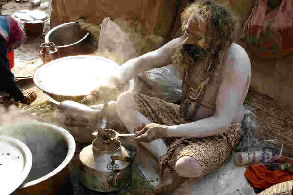 A naga sadhu smeared in ash serves up the early morning tea for his akhara, or sect, one of 13 that has its own camp on the 20-square-mile grounds.