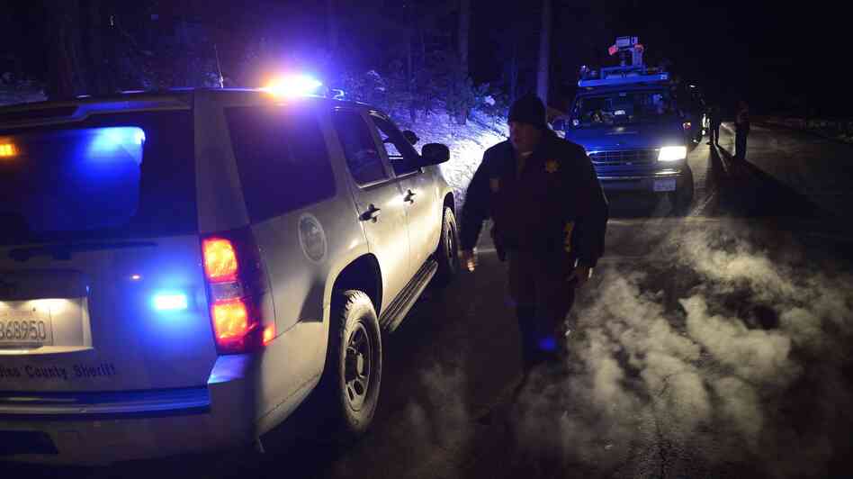 Police patrol a road block on Highway 38 into the Big Bear area where a shoot-out with suspected fugitive Christopher Dorner resulted in the death of one deputy in Angelus Oaks, Calif., on Tuesday.
