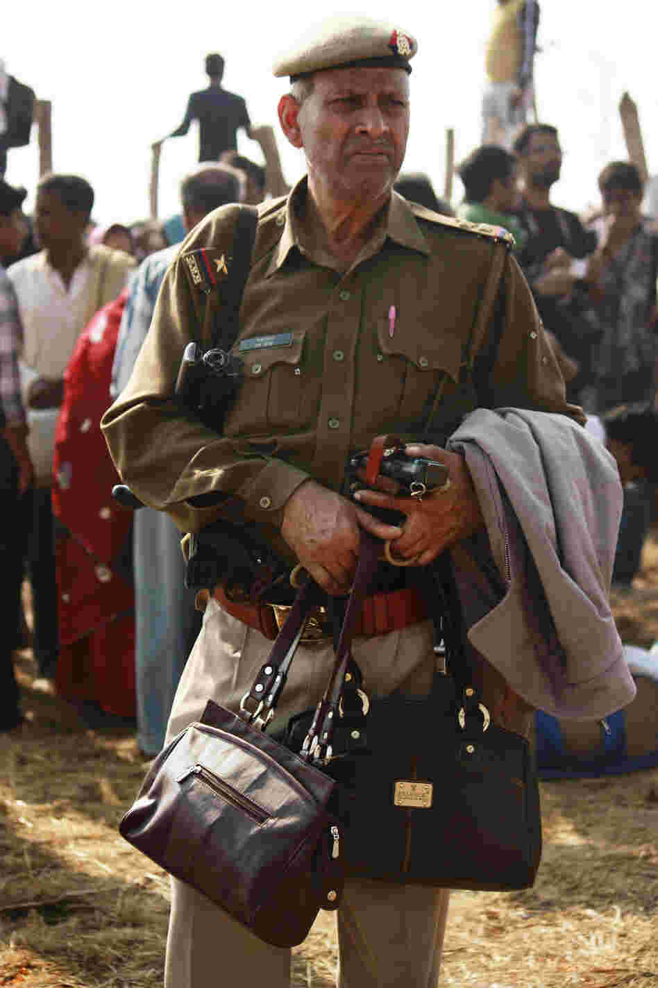 An officer guards the purses of pilgrims who came to pay homage to the holy waters at the confluence of the Ganges, Yamuna and the mythical Saraswati rivers.