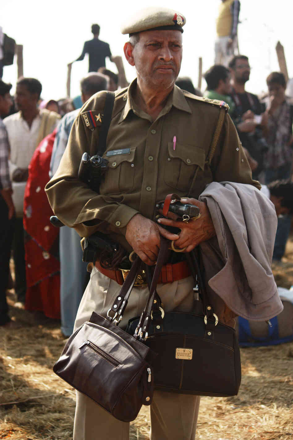 An officer guards the purses of pilgrims who came to pay homage to the holy waters at the confluence of the Ganges, Yamuna and the mythical Saraswati rivers.