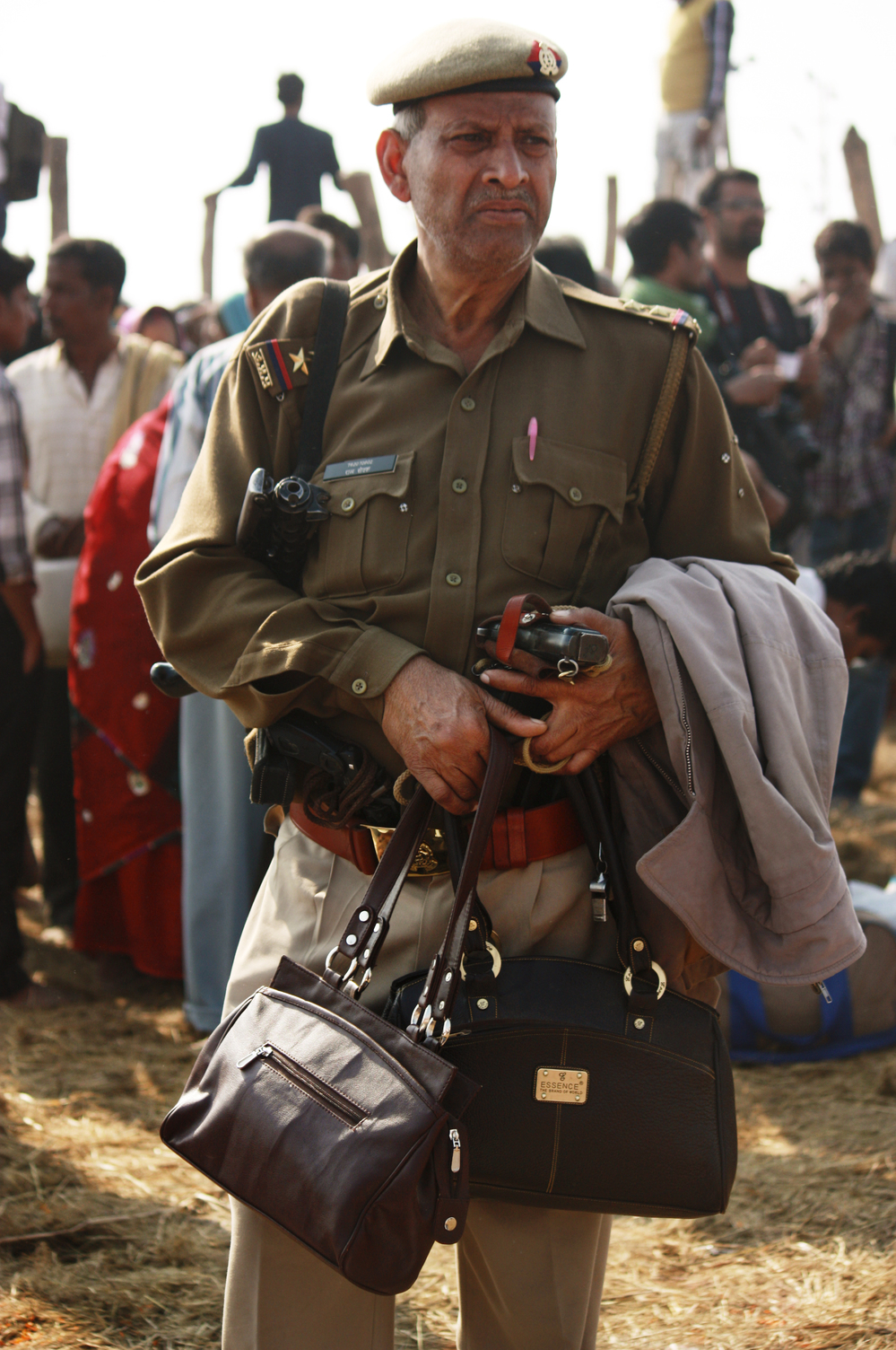 An officer guards the purses of pilgrims who came to pay homage to the holy waters at the confluence of the Ganges, Yamuna and the mythical Saraswati rivers.