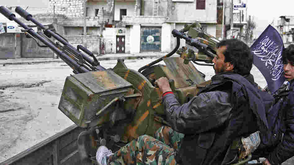 Syrian rebels say they captured an important military air base in northern Syria on Tuesday. Here, rebels sit behind an anti-aircraft weapon in the northern city of Aleppo on Friday.