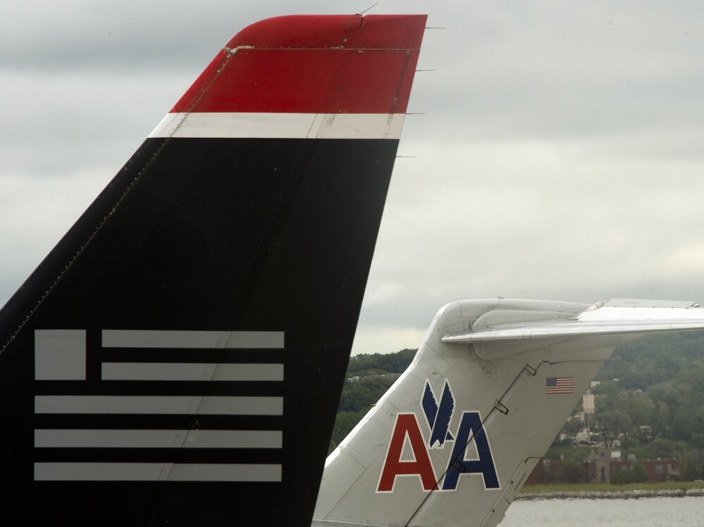 A US Airways jet rests on the tarmac near an American Airlines plane at Ronald Reagan Washington National Airport in Arlington, Virginia.
