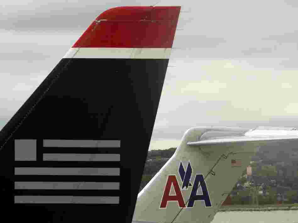 A US Airways jet rests on the tarmac near an American Airlines plane at Ronald Reagan Washington National Airport in Arlington, Virginia.