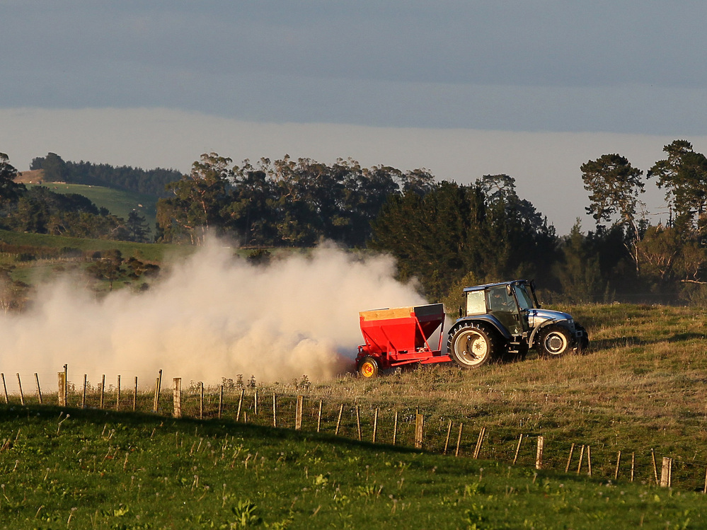 A tractor spreads fertilizer at a dairy farm in Morrinsville, New Zealand.