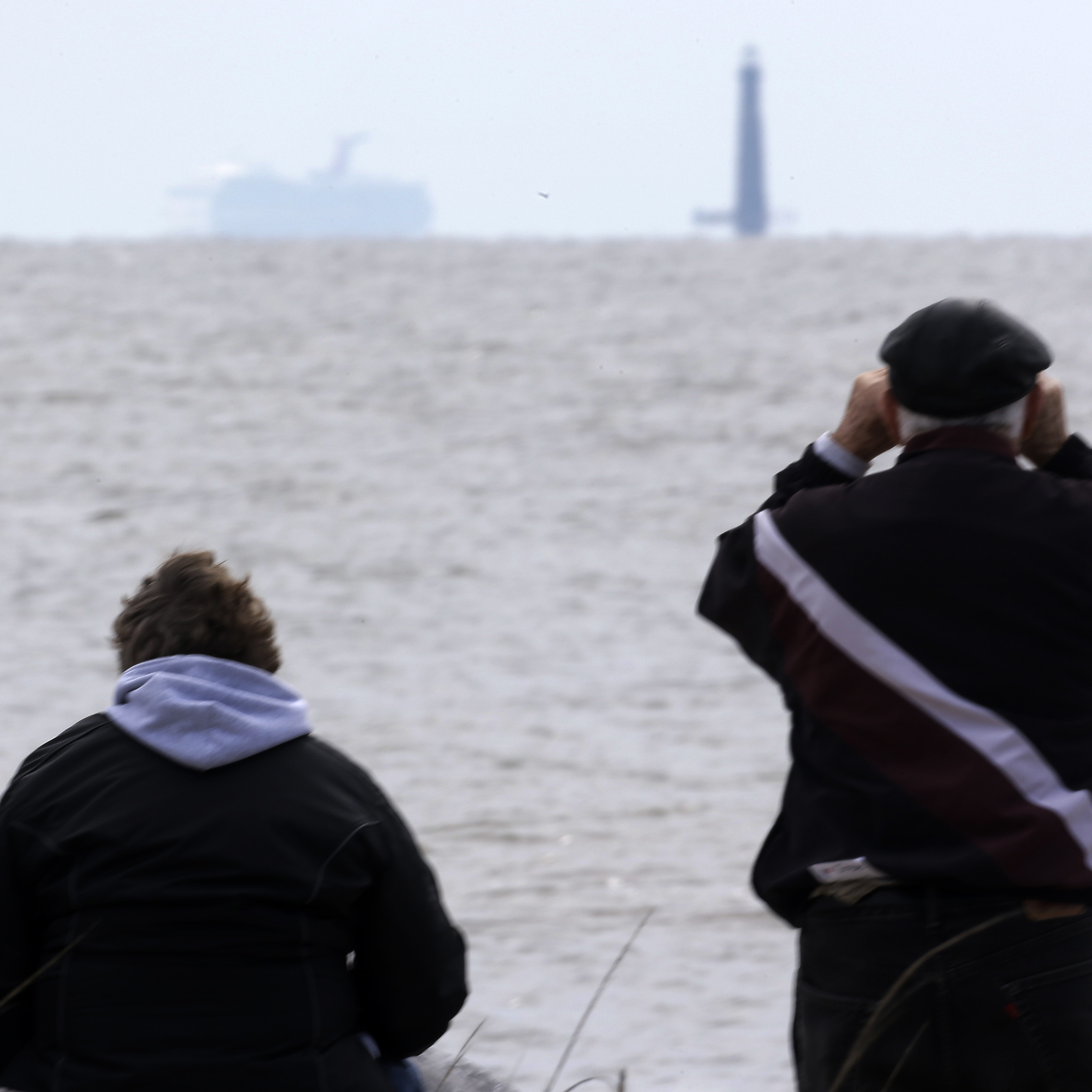 Spectators watch the Carnival cruise ship Triumph near Dauphin Island, Ala., Thursday, as the ship is towed to a terminal in Mobile. The Triumph is expected to arrive late Thursday night.
