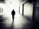 A man walks through a downtown alley into the light in Calgary, Canada.