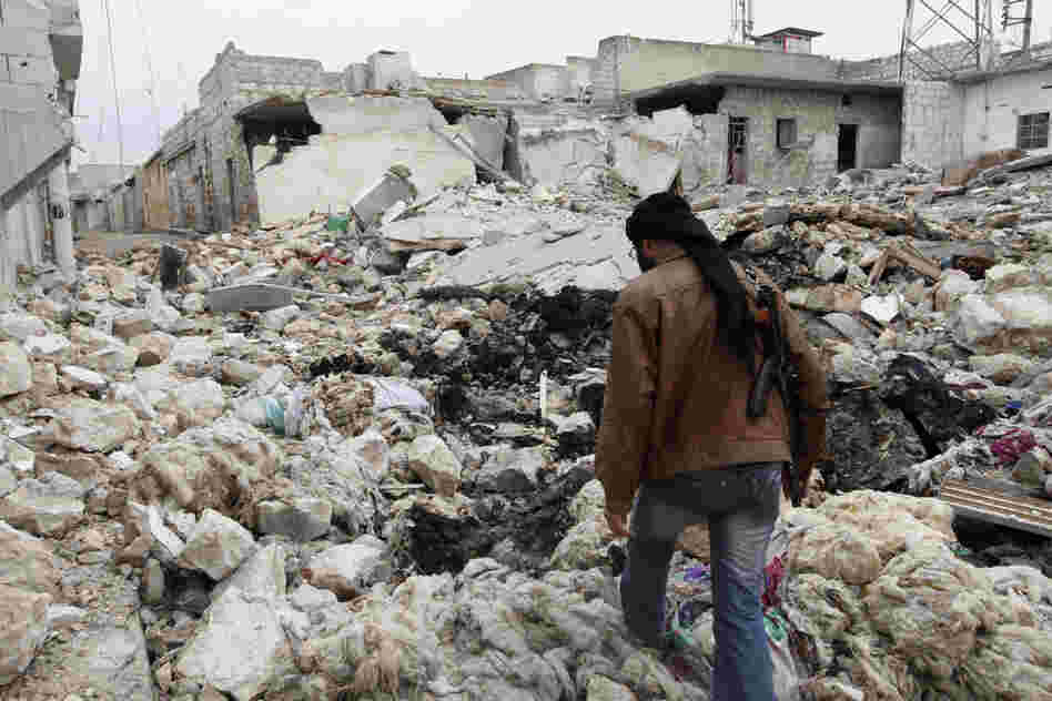 A Free Syrian Army fighter walks among the rubble of damaged buildings near a cement factory in Aleppo earlier this month.