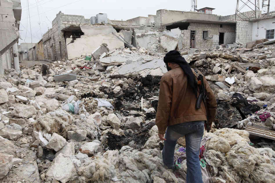 A Free Syrian Army fighter walks among the rubble of damaged buildings near a cement factory in Aleppo earlier this month.