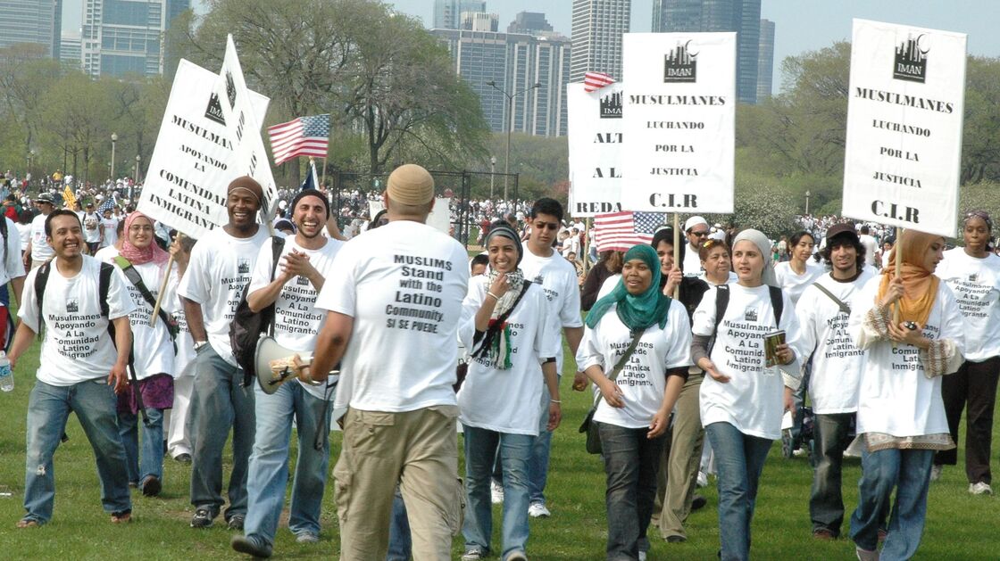 Rami Nashashibi, fourth from left, claps as he marches with IMAN leaders during a May Day immigration rally in Chicago in 2007.