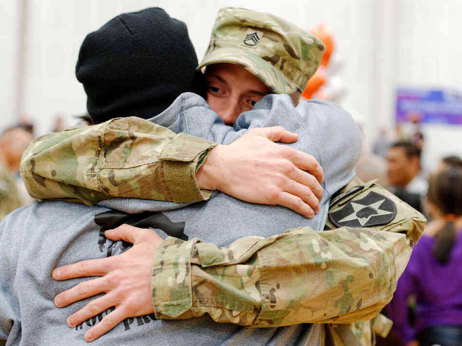 As family and friends welcome the returning soldiers, Staff Sgt. Michael Blair gives Jeffries a bear hug.