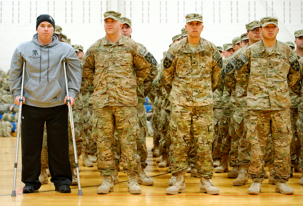As part of homecoming ceremonies at Joint Base Lewis-McChord in Washington state in January, Army Spc. Tyler Jeffries — with crutches and prosthetic legs — joins his unit in formation as the national anthem is played. The homecoming marked the first time Jeffries had seen his platoon since he lost both his legs in a roadside bombing in Afghanistan last October.