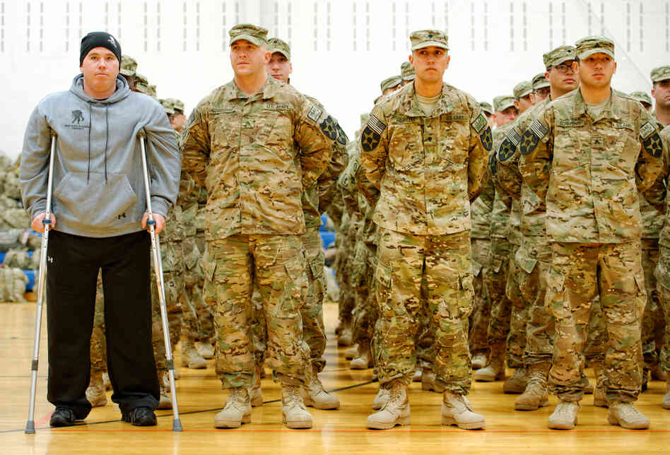 As part of homecoming ceremonies at Joint Base Lewis-McChord in Washington state in January, Army Spc. Tyler Jeffries — with crutches and prosthetic legs — joins his unit in formation as the national anthem is played. The homecoming marked the first time Jeffries had seen his platoon since he lost both his legs in a roadside bombing in Afghanistan last October.