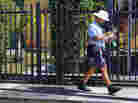 A mailman for the U.S. Postal Service delivers mail on November 15, 2012 in Miami, Florida.