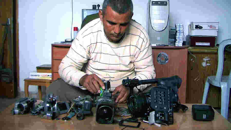 Emad Burnat, a Palestinian who co-directed the Oscar-nominated documentary 5 Broken Cameras, displays the cameras destroyed by Israeli settlers and security forces. The film focuses on a Palestinian village protesting Israel's separation barrier in the West Bank.