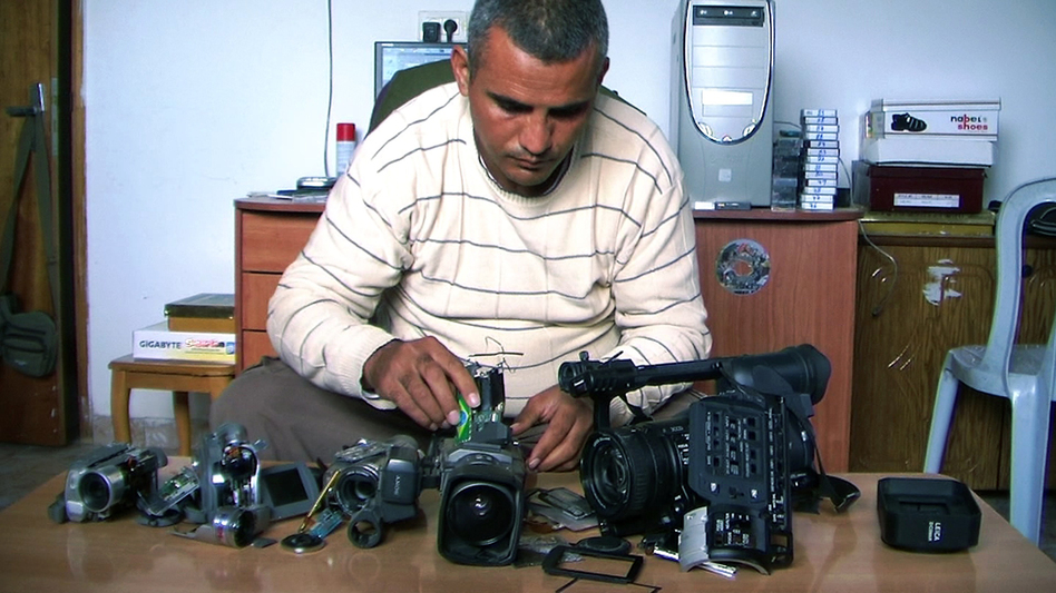 Emad Burnat, a Palestinian who co-directed the Oscar-nominated documentary 5 Broken Cameras, displays the cameras destroyed by Israeli settlers and security forces. The film focuses on a Palestinian village protesting Israel's separation barrier in the West Bank.