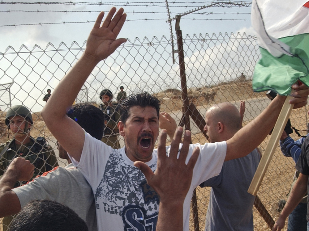 With Israeli soldiers on the other side, Palestinians protest against Israel's West Bank separation barrier in the town of Bil'in in 2008.