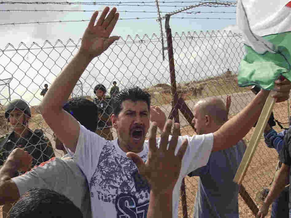 With Israeli soldiers on the other side, Palestinians protest against Israel's West Bank separation barrier in the town of Bil'in in 2008.