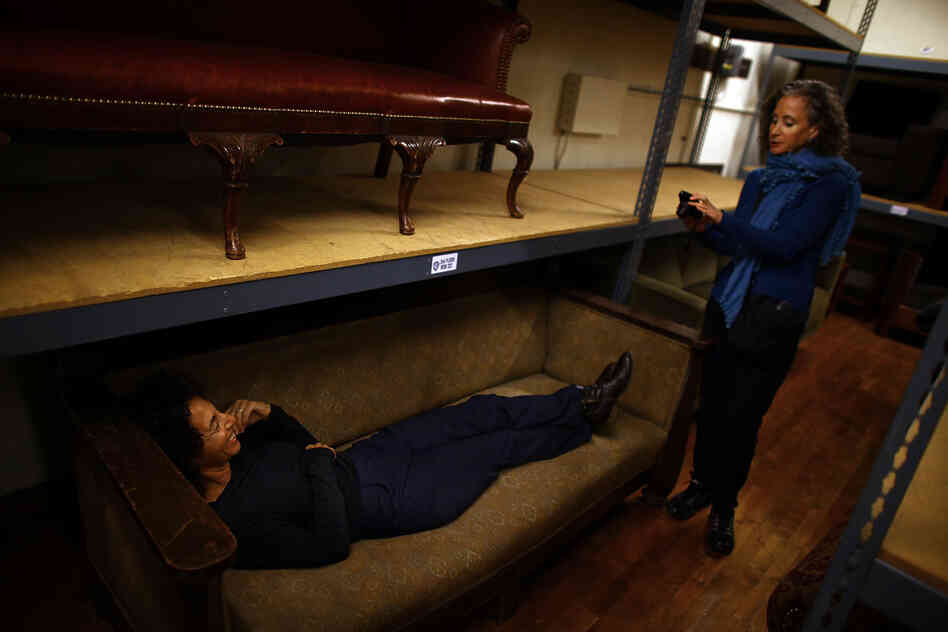 Set decorator Lauri Gaffin tests out a couch for an upcoming Johnny Depp film. Assistant set decorator Florence Fellman takes a photo so the two can confer with the production designer.