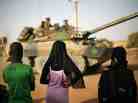 Malian teenagers watch French soldiers pass through Gao, in northern Mali, Tuesday, Feb. 19, 2013.