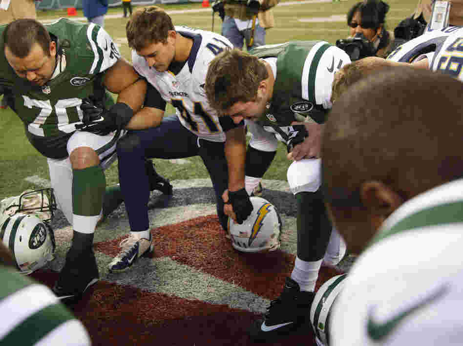 Tim Tebow, center, leads a prayer after the Jets' loss to San Diego Chargers on December 23.
