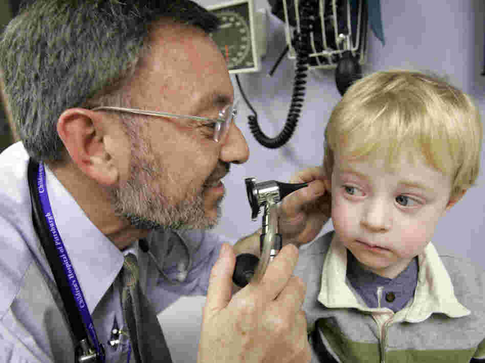 Giancario Gemignani-Hernandez, 2, of Pittsburgh has his ear examined by Dr. Alejandro Hoberman.