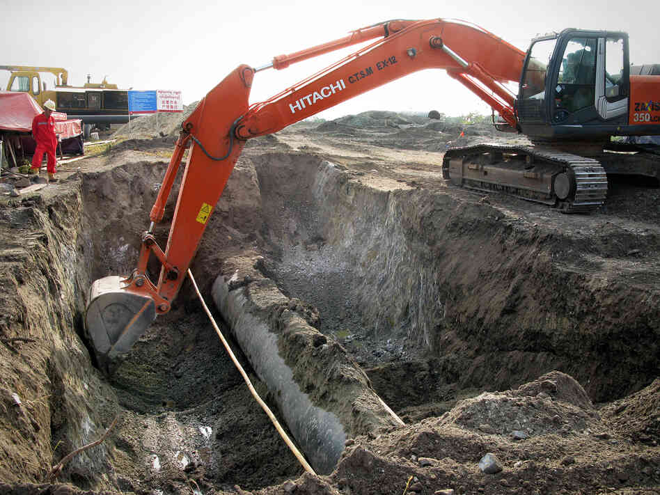 Engineers from China and Myanmar work to bury an oil pipeline outside the Myanmar city of Mandalay. Chinese media reports say the 700-mile-long oil and gas pipelines will be completed in May.