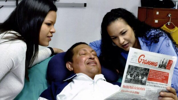 A handout picture made available Friday by the Venezuelan Ministry of Communications and Information shows Venezuelan President Hugo Chavez and his daughters  Rosa Virginia (right) and Maria Gabriela reading an edition of Cuban daily Granma, as he recovers from cancer surgery. It was reportedly taken on Thursday.