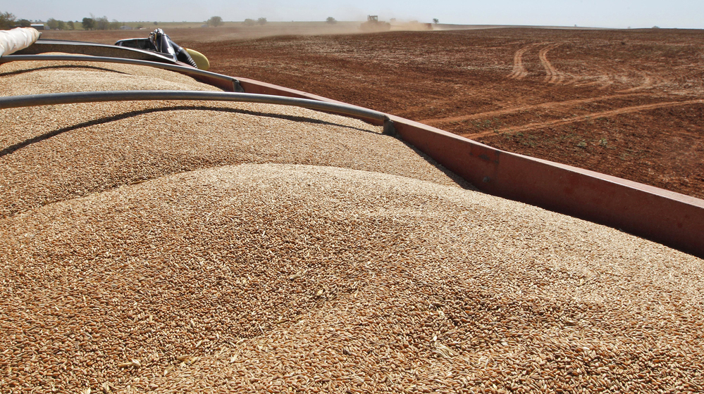 John Honeywell uses a grain drill to plant winter wheat near Orlando, Okla., on Sept. 12, 2012.
