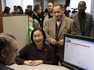 Oakland Mayor Jean Quan (center) and former Oakland Councilman Ignacio De La Fuente are registered for the Oakland City ID Prepaid MasterCard program by Jaime Suriano (left) Feb. 1 in Oakland, Calif.