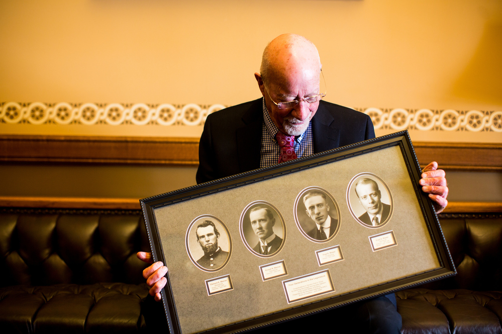 Risser holds a frame with photos of four generations of legislators in his family. His father, Fred E. Risser was a state senator; his grandfather, Ernest Warner, was an assembly member; and his great-grandfather, Clement Warner, was a state senator and assembly member following the Civil War.