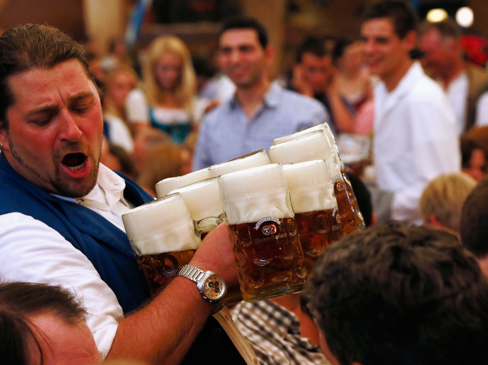 A waiter carries beer mugs through the Braeurosl beer tent during the 2012 Oktoberfest beer festival in Munich, Germany.