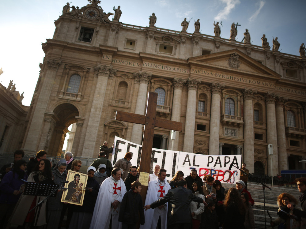 A church group prepares to pray for Pope Benedict XVI on the steps of St. Peter's Basilica on Tuesday.