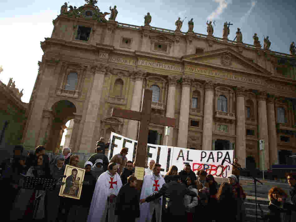 A church group prepares to pray for Pope Benedict XVI on the steps of St. Peter's Basilica on Tuesday.
