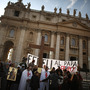 A church group prepares to pray for Pope Benedict XVI on the steps of St. Peter's Basilica on Tuesday.