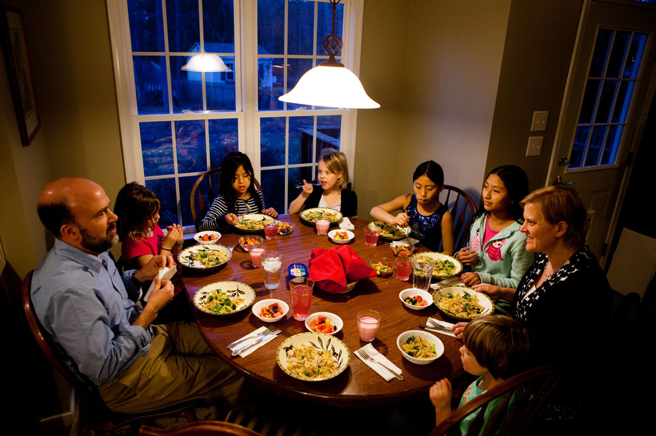 The Brown-Spencer family gathers for dinner at their home in Mechanicsville, Va. This family of eight manages to eat together nearly every weeknight, but they've had to cut back on many after-school activities to make it work. From left: Doug Brown, Laura, Celedonia, Anna, Miriam, Anita, Amy Spencer and Gavin.