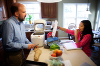Brown makes dinner rolls while helping his seventh-grader, Anita, with math homework.
