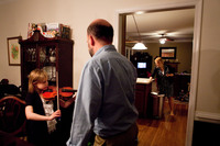 Anna, 8, practices the viola with her stepdad as her mother cleans up after dinner. All five of their daughters play an instrument and practice after dinner four nights a week.