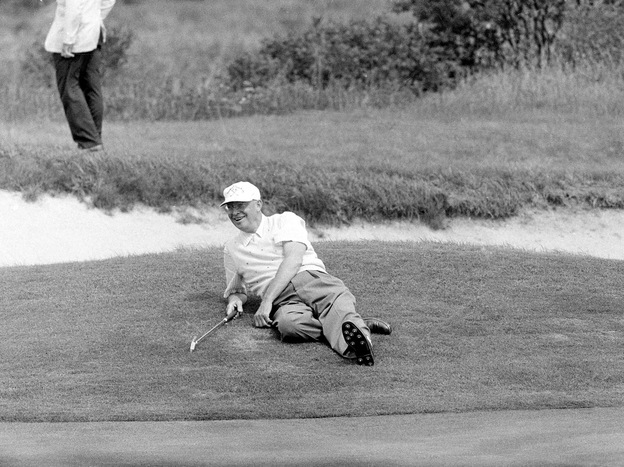 U.S. President Dwight Eisenhower relaxes at the 18th hole during a golf game in Newport, R.I., Sept. 10, 1957.
