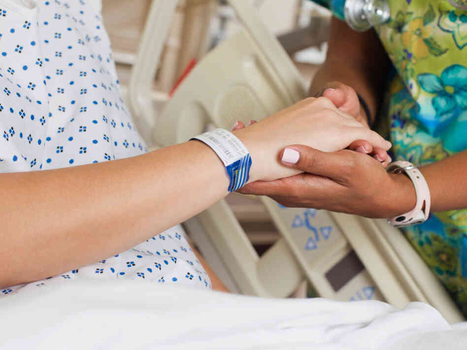 Nurse comforting patient in hospital