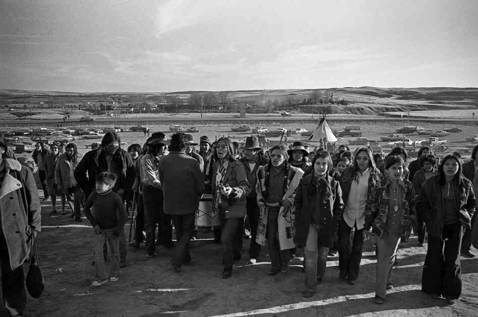 The drum leads the people to the mass grave of those who were killed in the 1890 massacre at Wounded Knee.