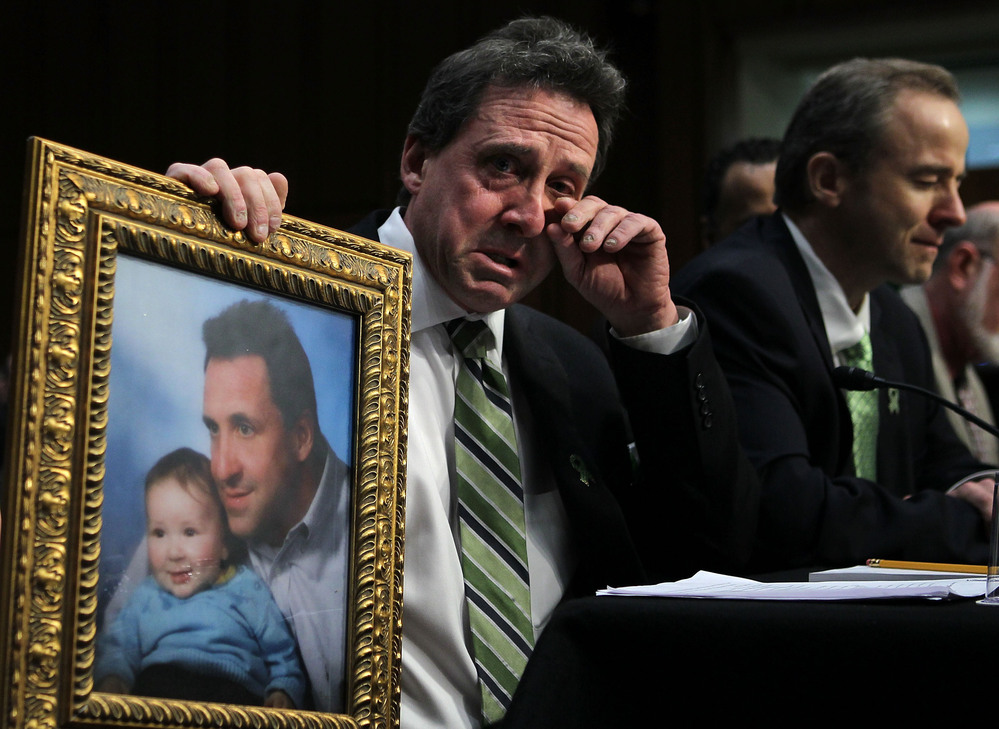 Neil Heslin, father of six-year-old Sandy Hook Elementary School shooting victim Jesse Lewis, holds a picture of him with Jesse as he testifies during a hearing before the Senate Judiciary Committee on Wednesday.