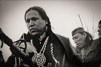 Crow Dog leads prayers and blessing for two warriors who had been wounded when they were shot in the legs.